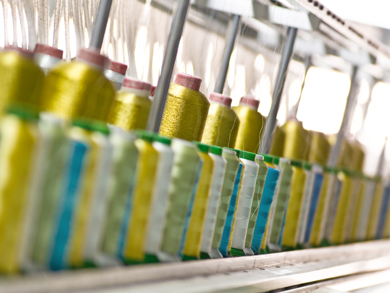 Spools of yellow yarn at a textile manufacturing plant. Credit: ID 5468768 © Hooverphonic | Dreamstime.com